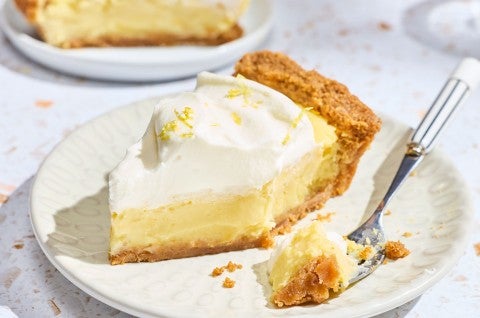 A Lemon Cream Pie slice with a bite on a fork. - select to zoom