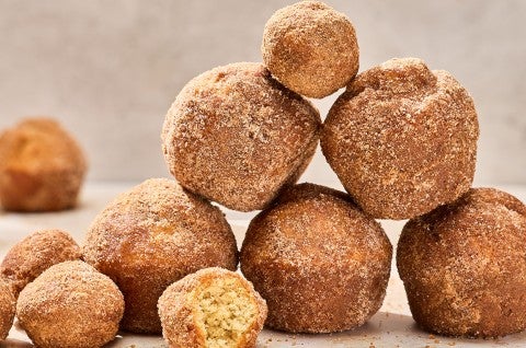 Maple French Toast Mini Muffins stacked together on a counter. - select to zoom