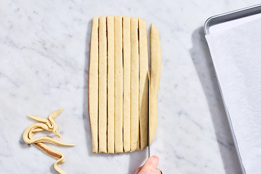 Sun Bun dough being cut into strips.