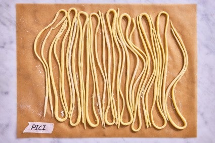 Pici pasta shape on a parchment-line baking sheet